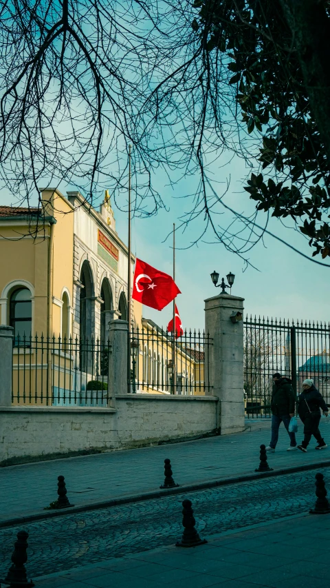 two people walking near the top of a fence