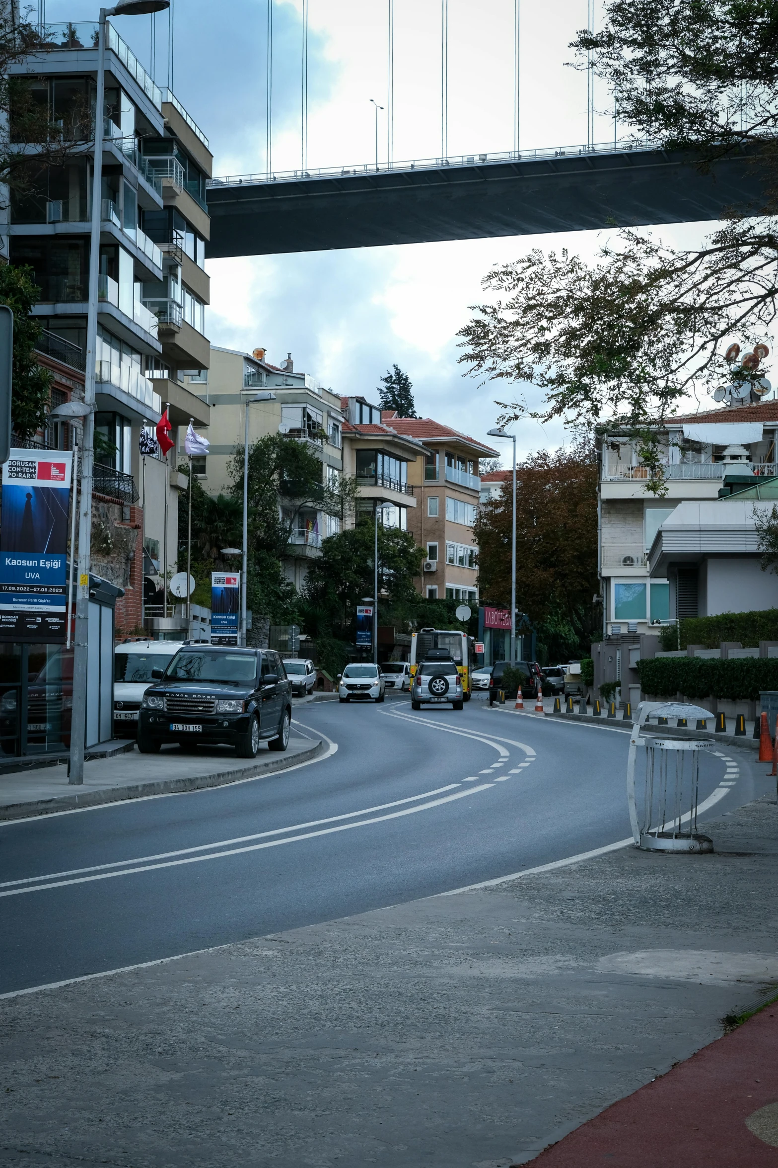 an image of a street with cars passing under a bridge