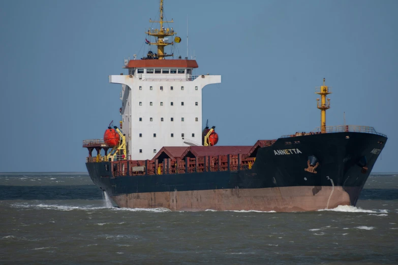 large ship sails in choppy waters off shore