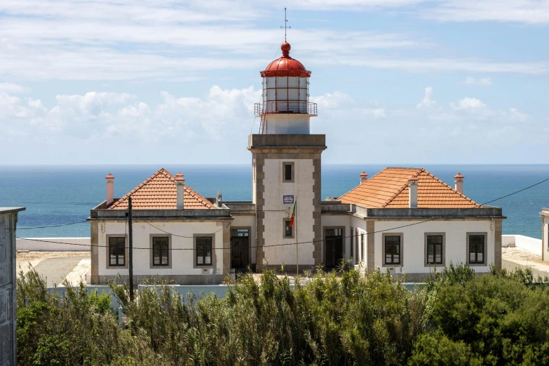 an old lighthouse sits next to a beach