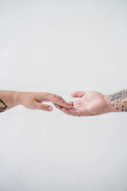 two people reaching out their hands together to each other