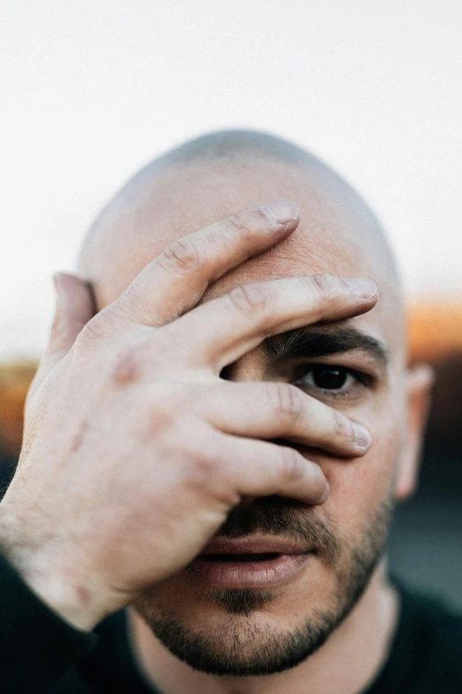 a man with his face covered by a shaved head