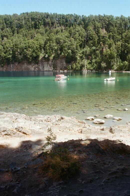 boats anchored on the sandy beach in the water