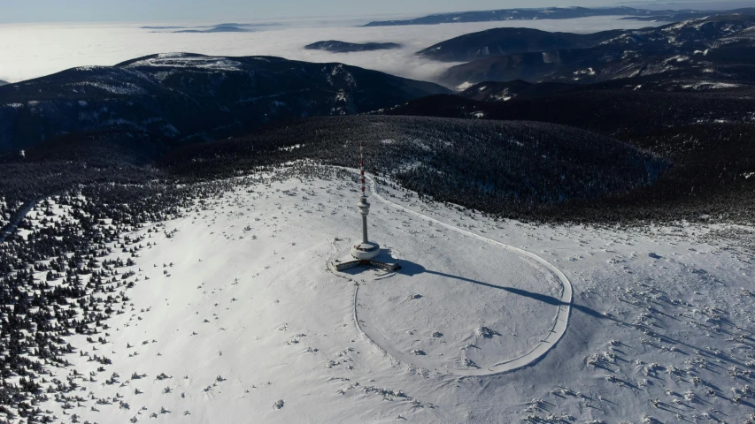 an aerial view of snow and mountains surrounding it