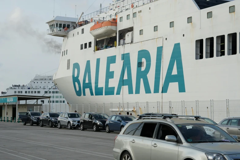 a large passenger ship docked next to a parking lot