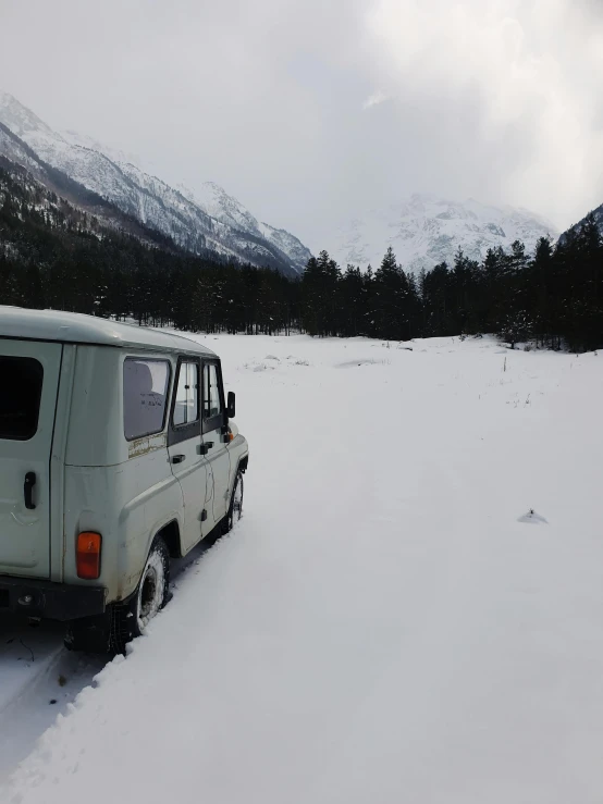 a van is driving through some snow covered mountains