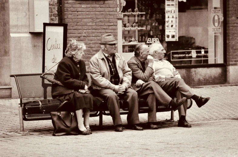 a group of people sitting on a bench in front of a store