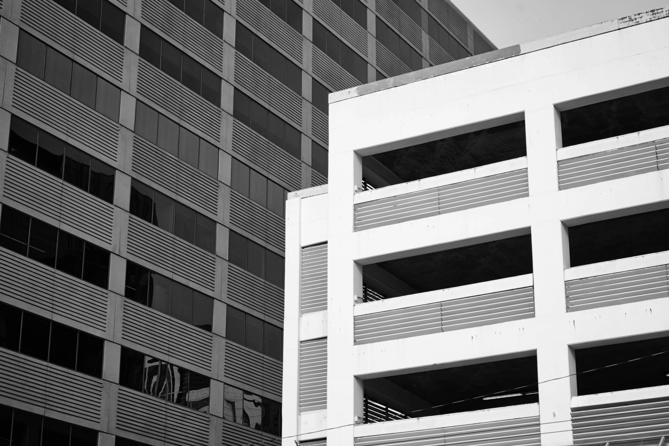 a large white building sitting in front of tall buildings