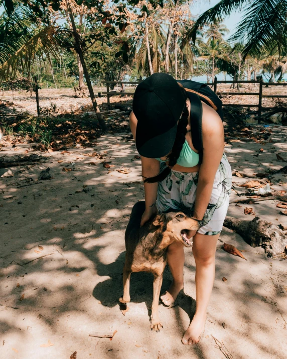 a person holds a small dog on a sandy beach