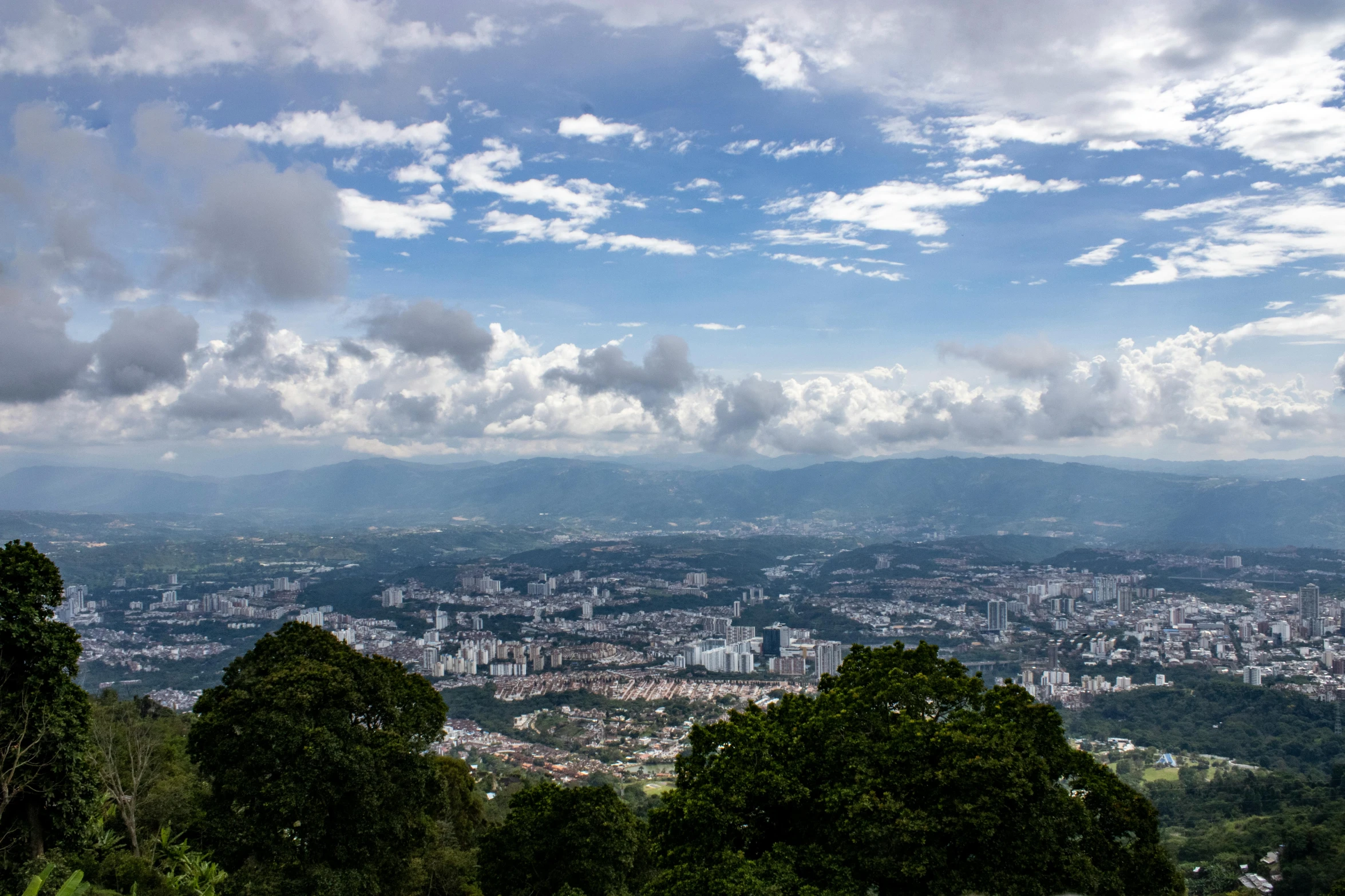 a po from a hill looking at some buildings and trees