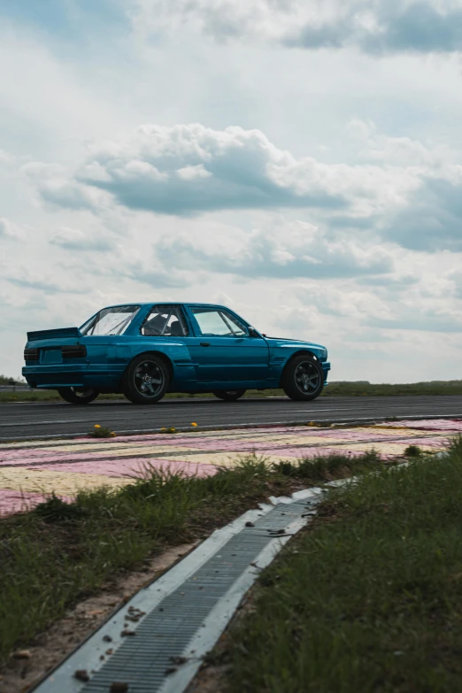 the blue car is driving along the dirt track