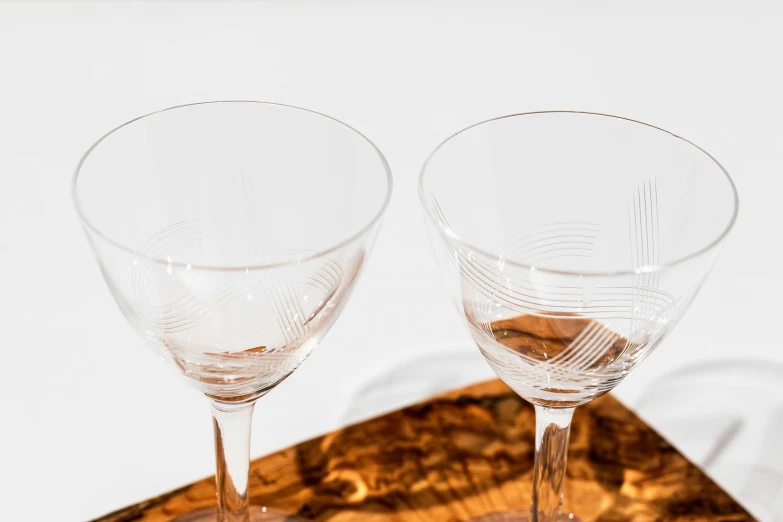 two empty wine glasses sit on a wooden table