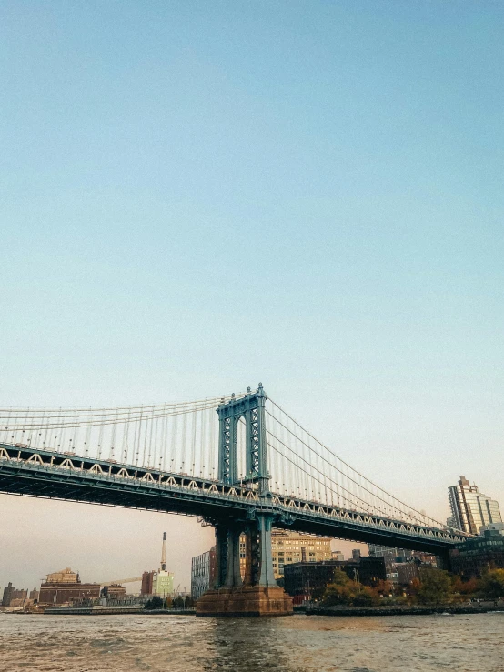 an airplane flying over a large bridge over a river