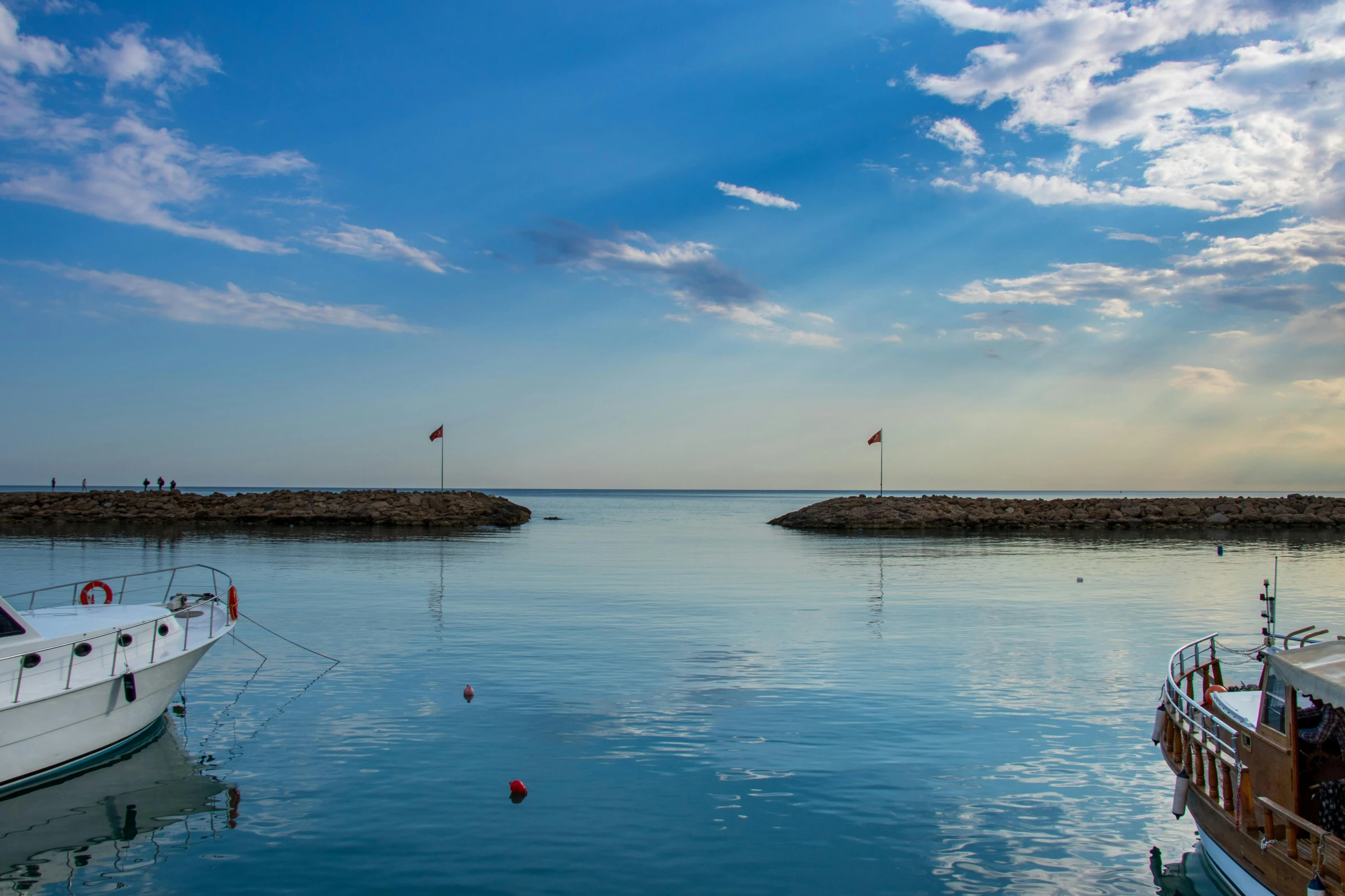 a lake with two small boats on it and blue skies