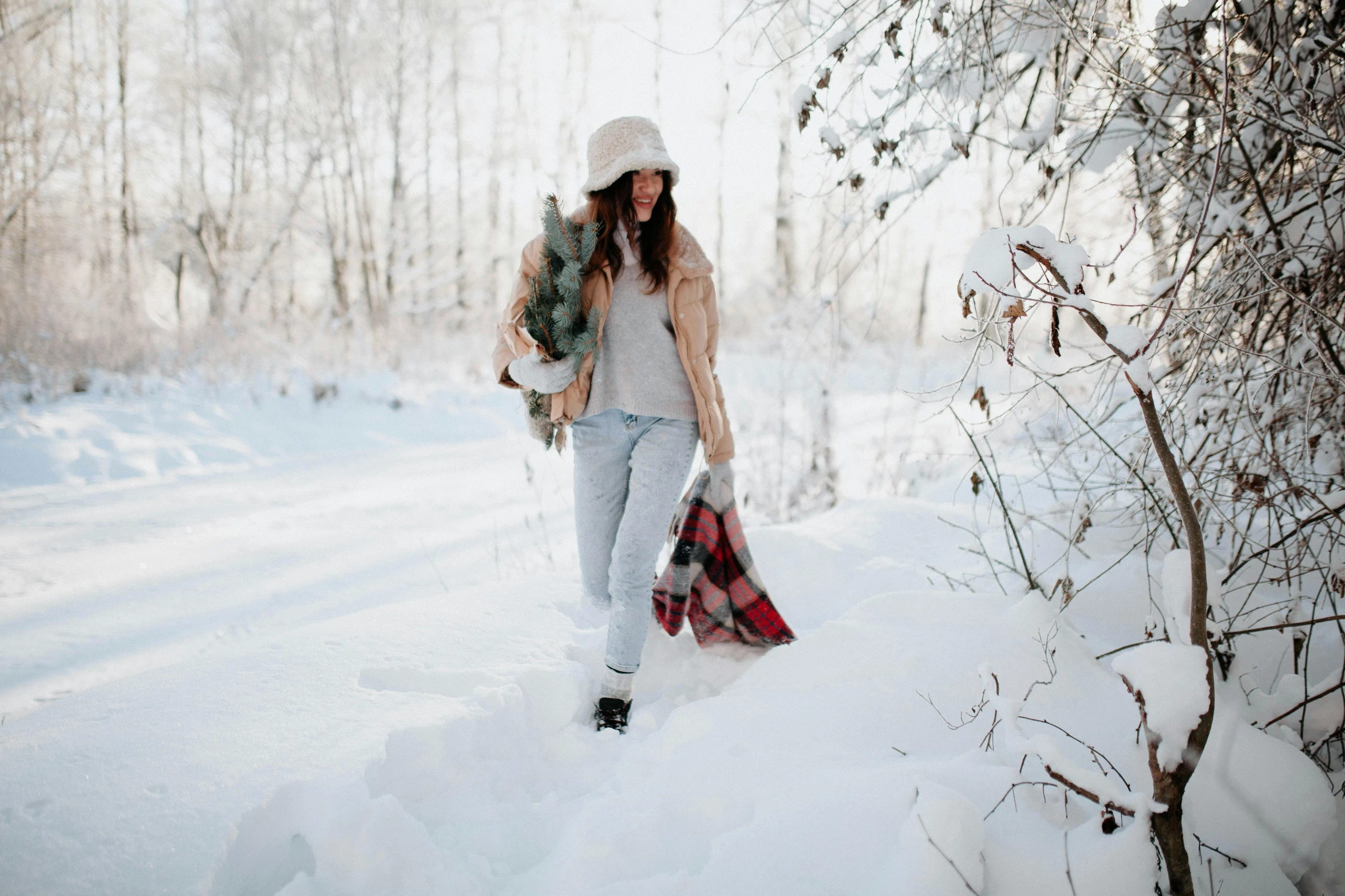 a woman carrying bags walks in the snow