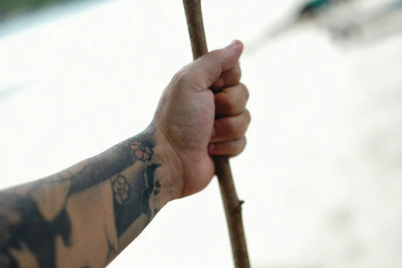 a close up of someone's arm holding a stick