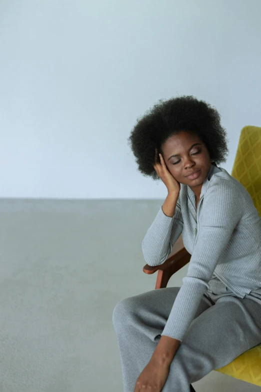 a woman sitting on a chair with her head down