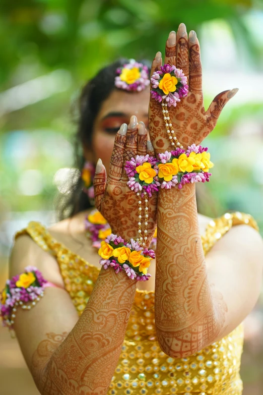 a woman in a dress holding her hands with flowers in her hair