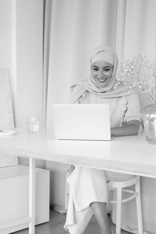 a young woman sitting in front of a laptop computer