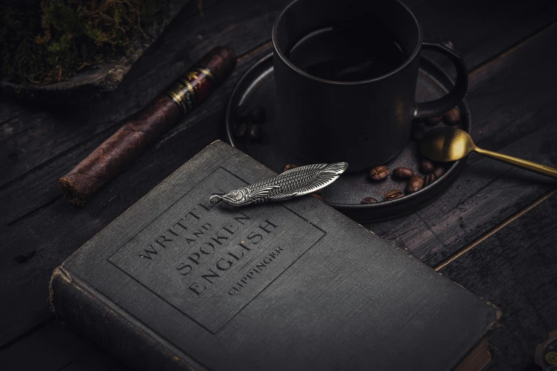 a book, coffee mug, and cigar sitting on a table