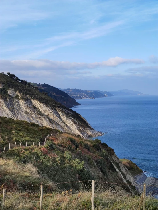 a hillside overlooking the ocean with a blue sky