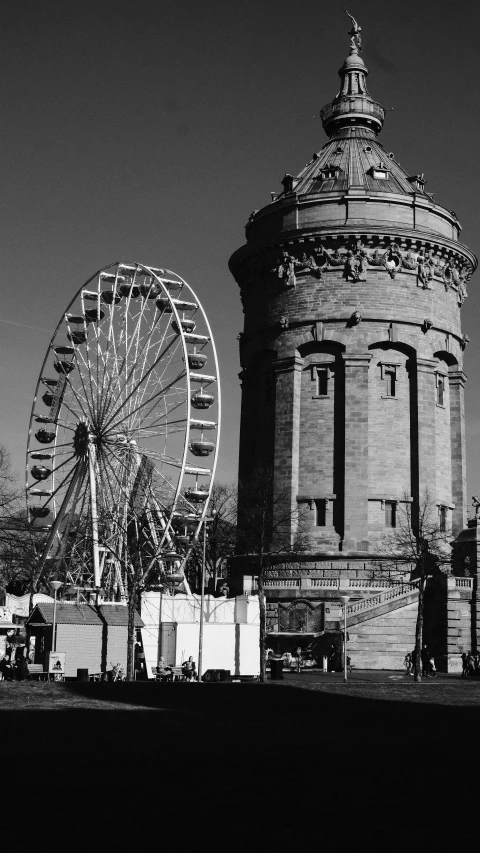 a black and white po of a ferris wheel and a small building