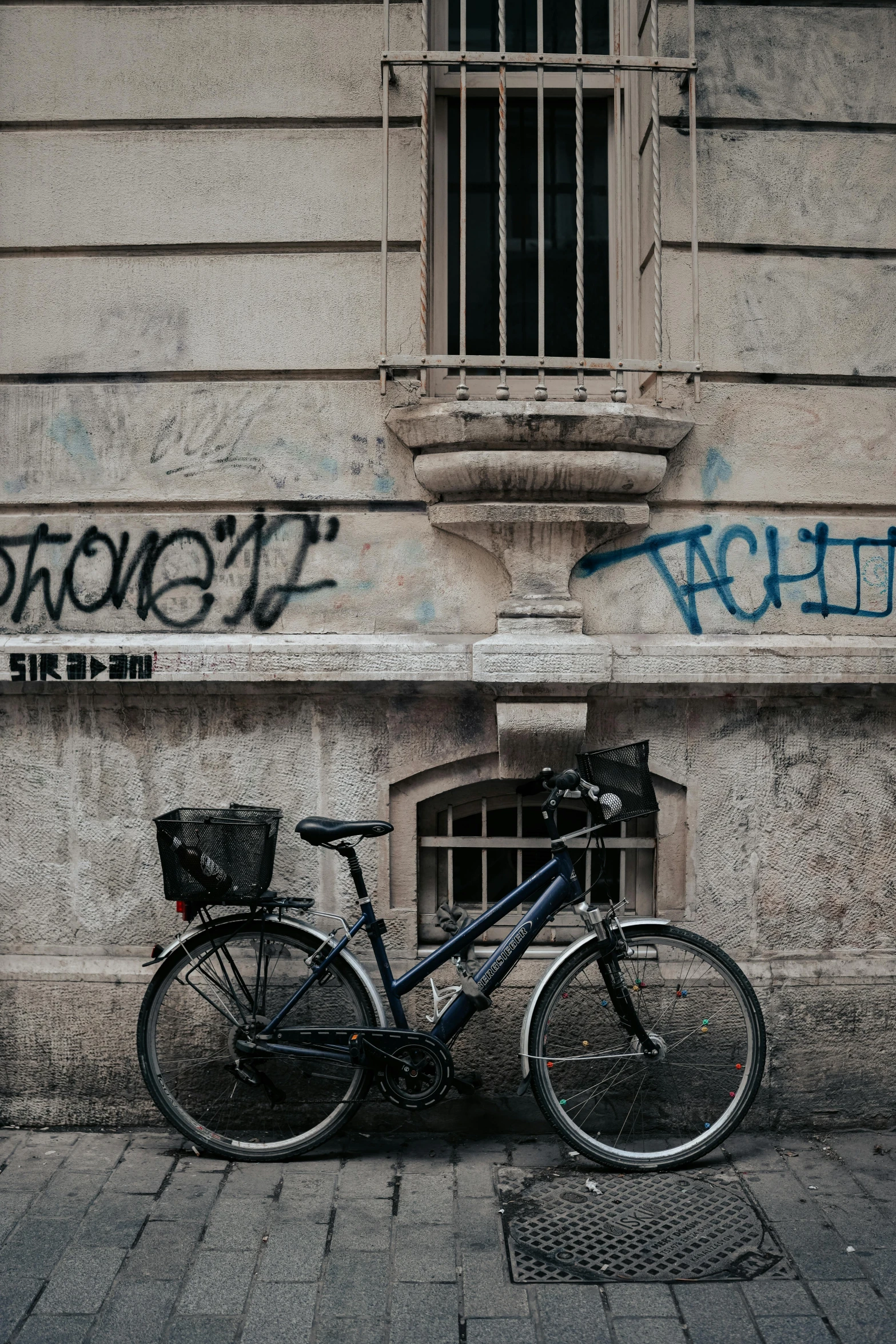 there is a blue bike and a black basket on the street