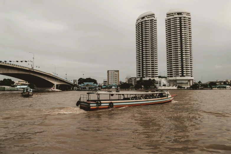 a boat in front of some tall buildings on the river