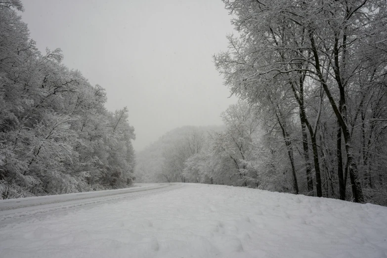 the road is covered in snow on a cold, dreary day