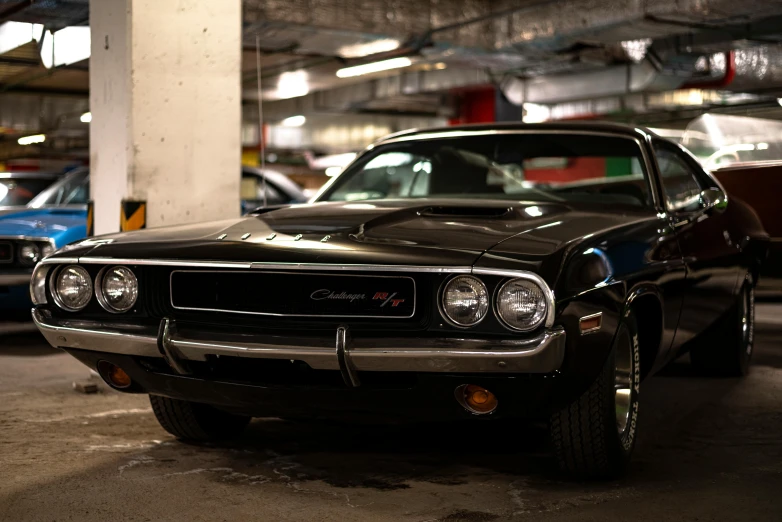 two cars parked in a car garage one is black and the other red