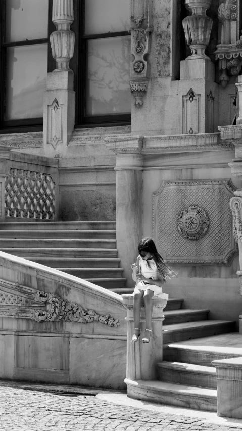 black and white pograph of woman sitting on concrete bench