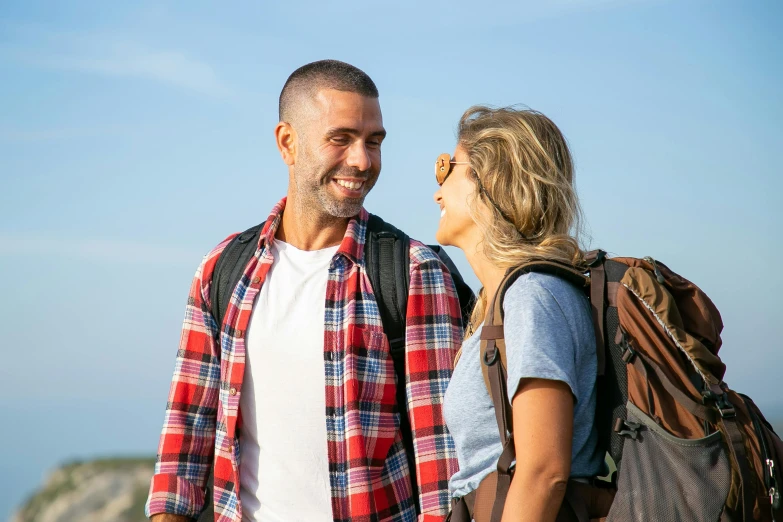 a woman and man are smiling while walking