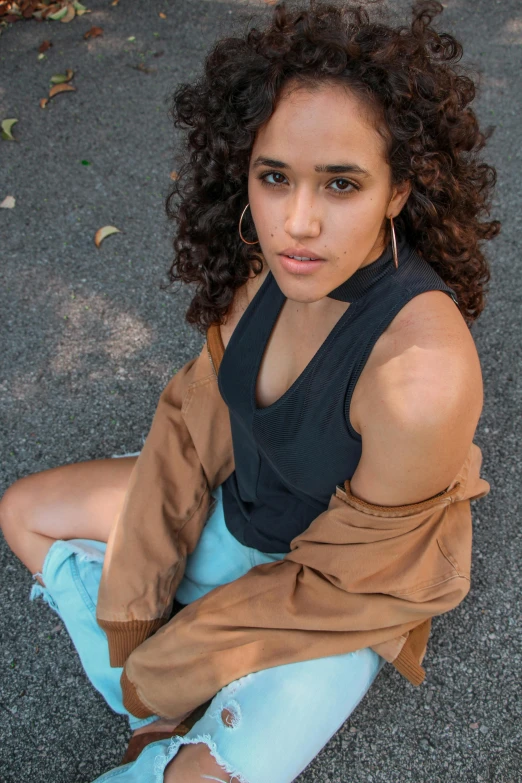 a young woman with a blue jean skirt and tan sweater