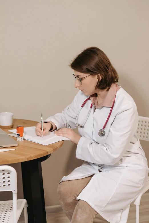 a woman sitting at a table writing a piece of paper