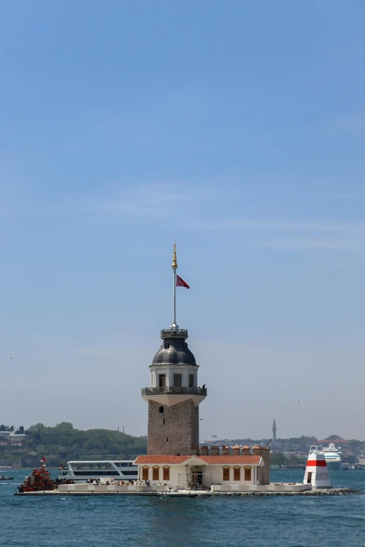 a lighthouse sitting on top of a stone pier next to a body of water