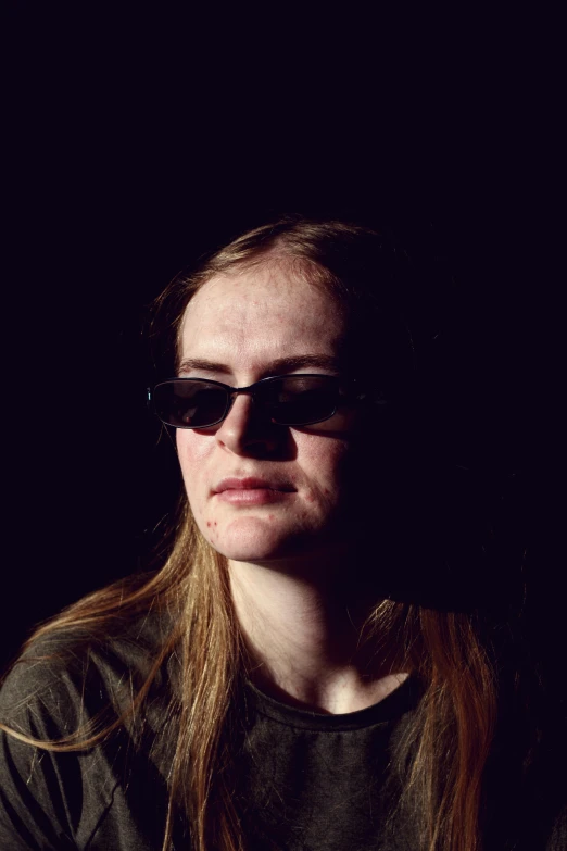 a woman wearing sunglasses on the left, against a black background