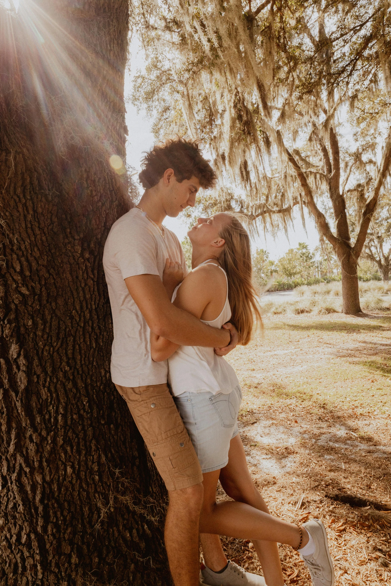 man and woman hugging each other near a tree