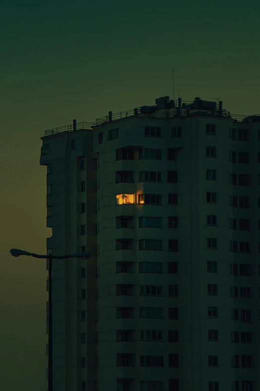 a tall building with several windows under a full moon