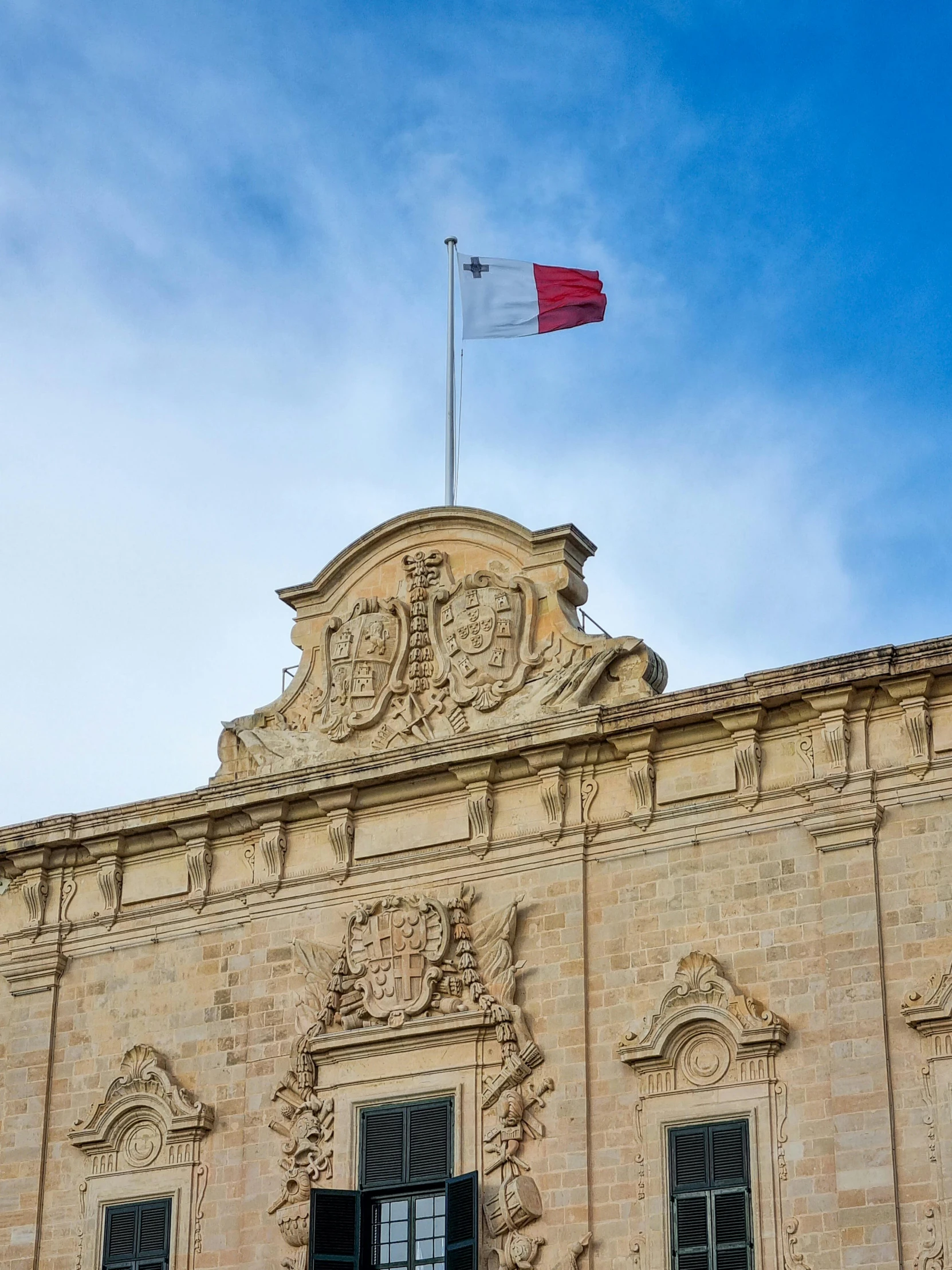 a flag flies high above the window of an old building