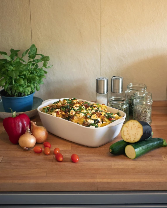 a dish of food is on a table with some vegetables