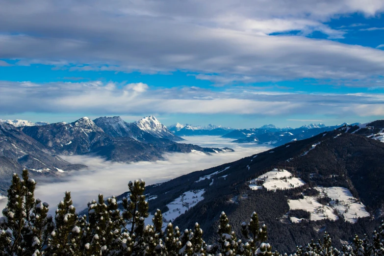 a couple of mountains surrounded by snow capped trees