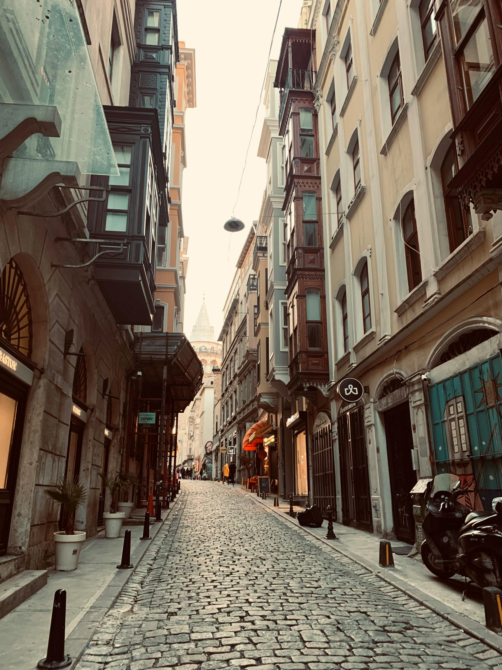 a brick street lined with buildings, bicycles, and a person walking on the sidewalk