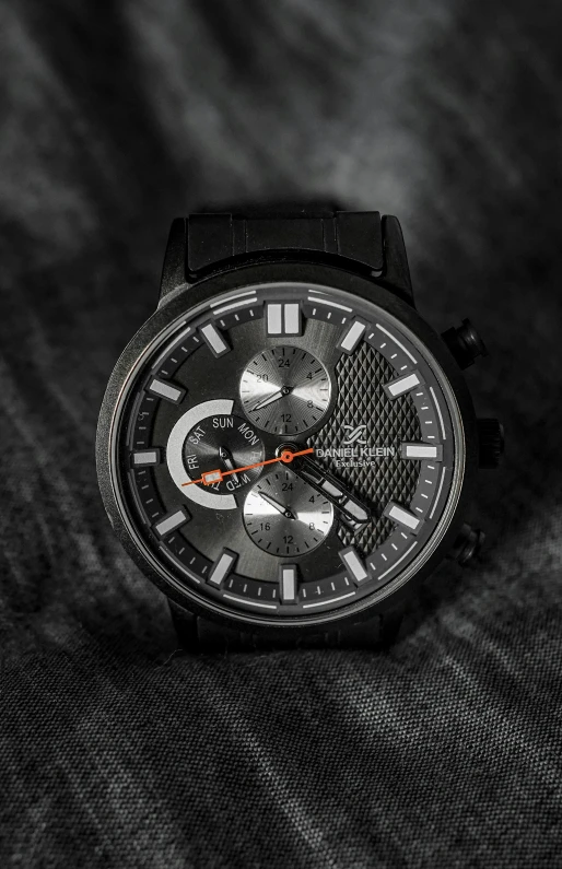 a watch with a silver face on the black surface