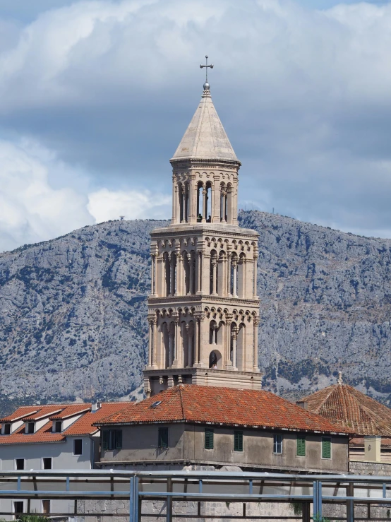 large stone tower in city setting near mountains