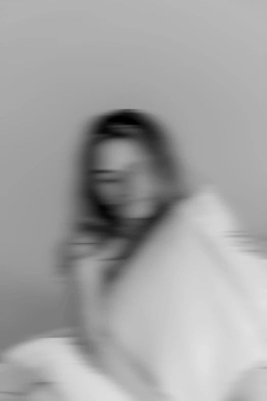 blurry image of a person sitting down on the phone