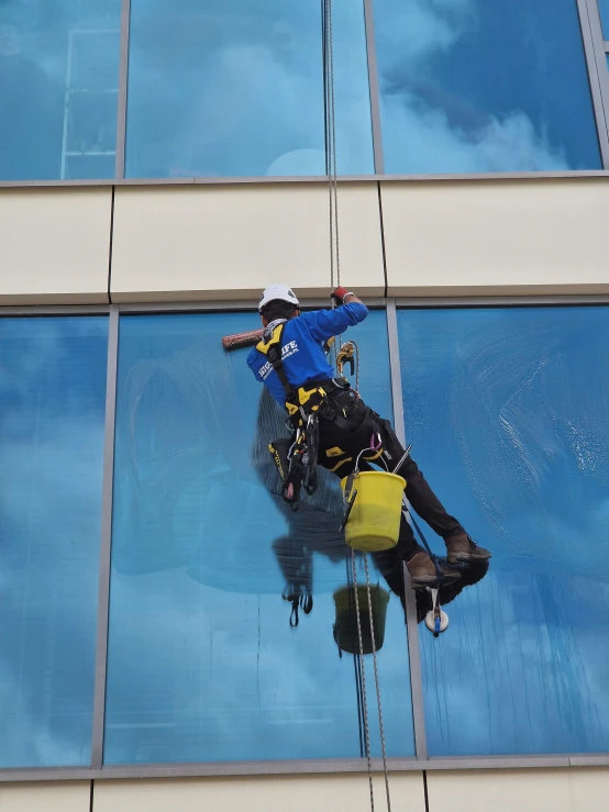 a person on a rope attached to a window with lots of windows