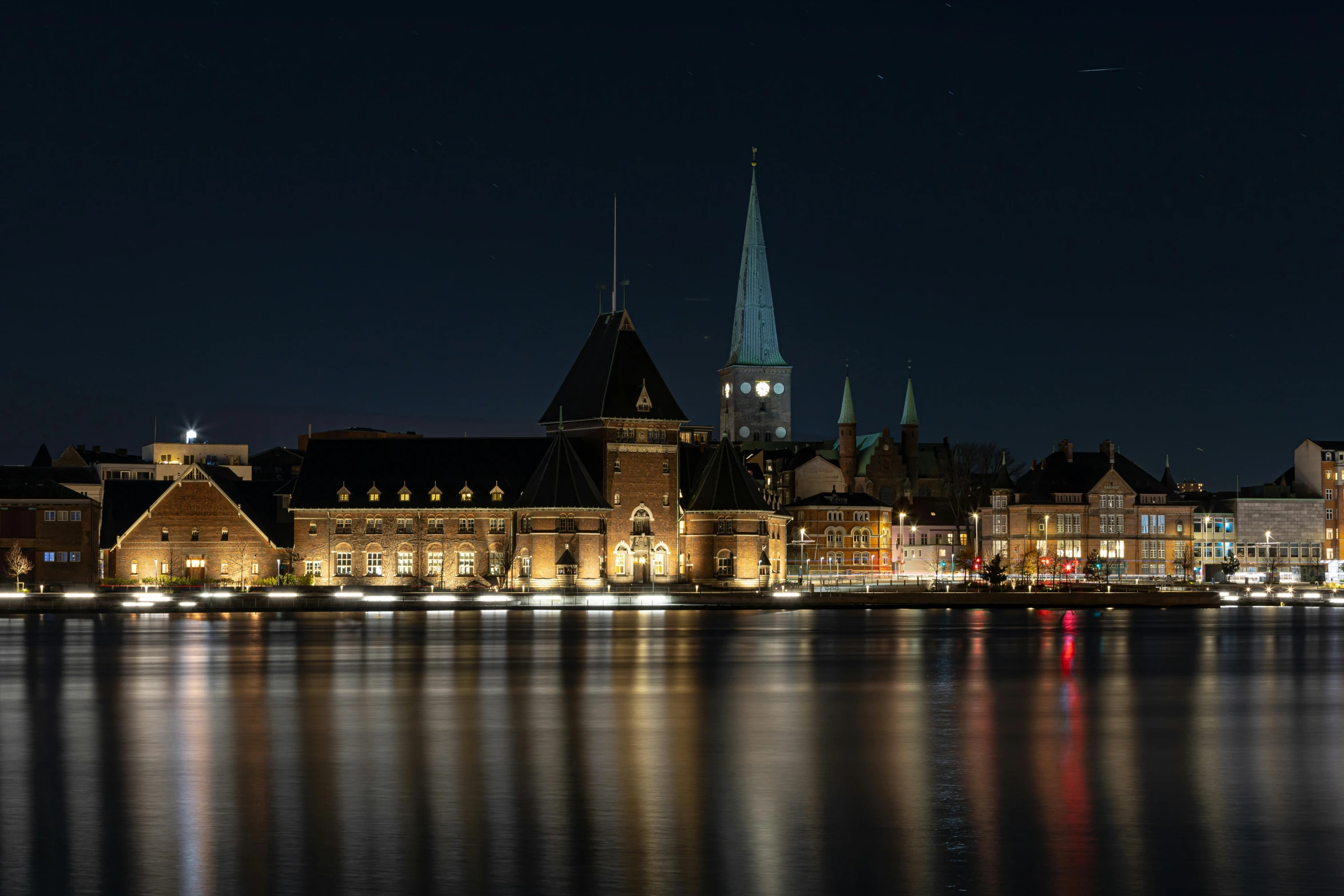 a nighttime scene with the city skyline reflecting off water