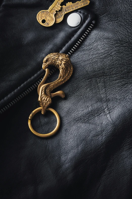 a black leather jacket with a golden key on the zip