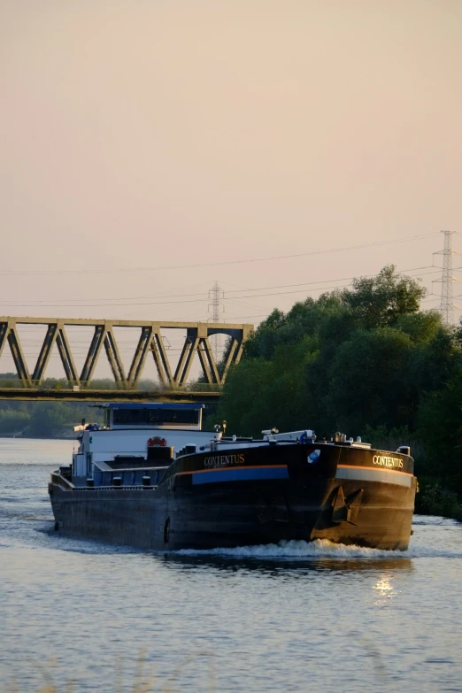 a couple of boats ride across the water under a bridge