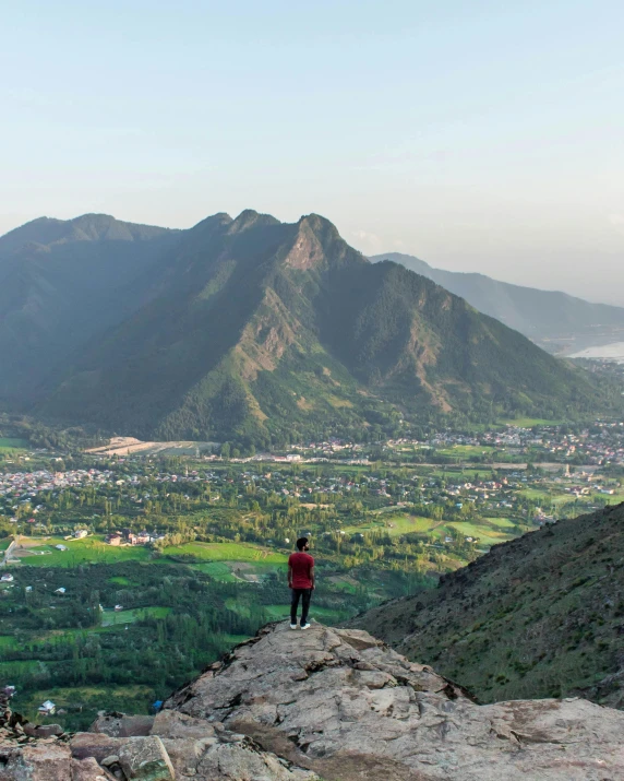 a person standing on top of a rock looking out over a valley